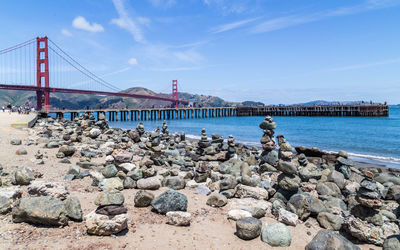 Suspension bridge over sea against sky