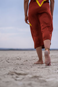 Low section from behind of woman walking on a desert