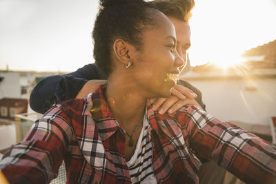 Happy affectionate young couple on rooftop in the evening