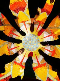 Low section of woman standing by multi colored umbrella