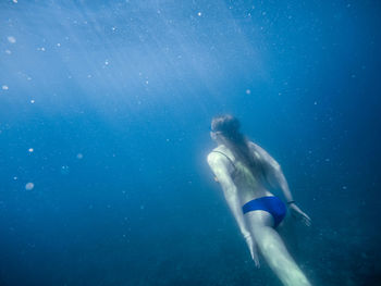 Girl swims underwater in the black sea