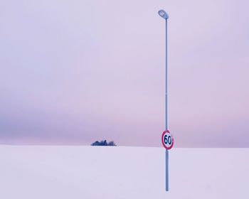 Information sign on snow against sky