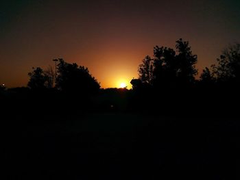 Silhouette trees against sky during sunset