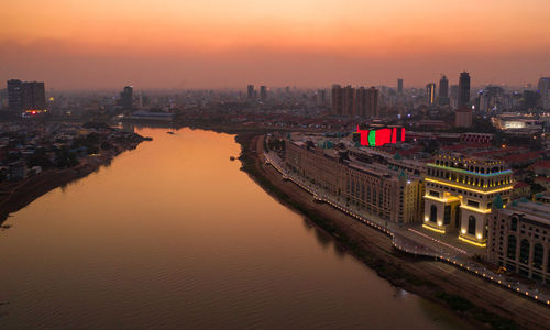 Illuminated buildings in city during sunset