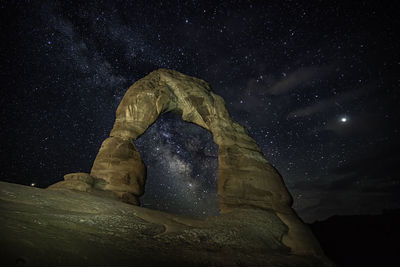 Low angle view of rock formation against sky at night