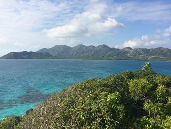 Scenic view of lake by mountains against sky