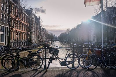 Bicycles on sidewalk in city against sky