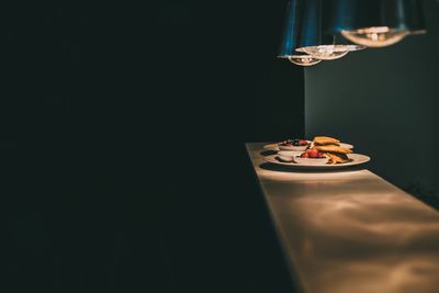 Pancakes with berry fruits in plate on table in darkroom