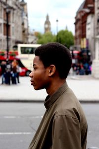 Side view of man looking away at city street