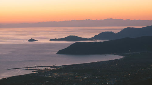 Scenic view of coastline against sky during sunset