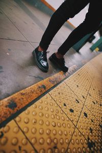 Low section of man standing at railroad station