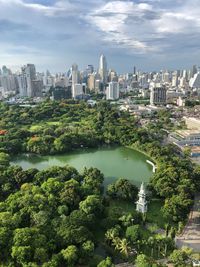 Trees and buildings in city against sky