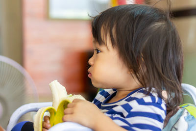 Cute baby girl eating banana