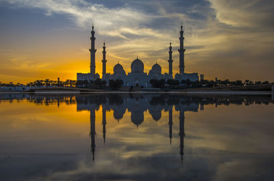 Reflection of buildings in water at sunset