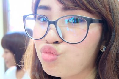 Close-up portrait of young woman puckering