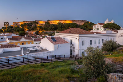 Buildings in town against clear blue sky