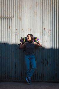 Young woman standing by corrugated iron