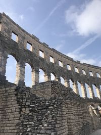 Low angle view of old building against cloudy sky