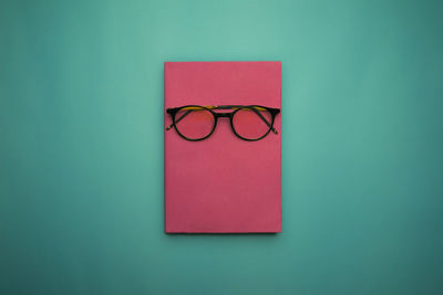 Close-up of eyeglasses on table against blue background