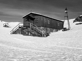 Abandoned building by sea against sky during winter