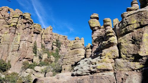 Low angle view of rocks against blue sky