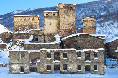 Built structure on snow covered mountain against sky