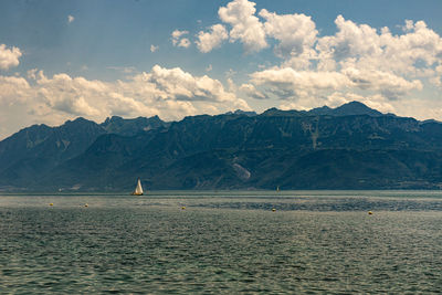 Scenic view of sea and mountains against sky