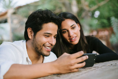 Portrait of smiling young man using mobile phone