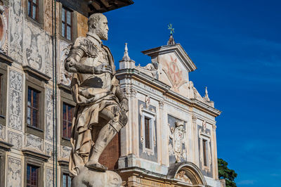 Low angle view of statues on building against sky