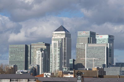 Modern buildings in city against cloudy sky