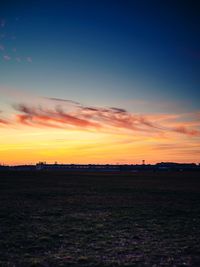 Scenic view of silhouette field against sky during sunset