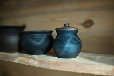 Close-up of pots on shelf at workshop