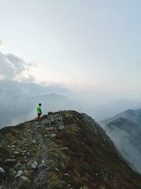 Man on rock against sky