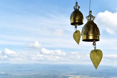Close-up of bell hanging against sky