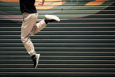 Low section of man jumping against shutter