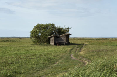 Barn on field against sky