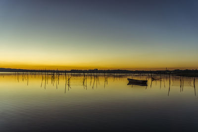 View of pier in sea at sunset