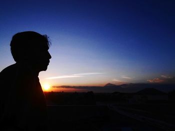 Silhouette man standing against sky during sunset