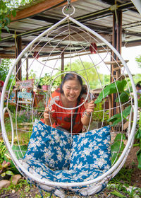 Portrait of smiling woman holding swing