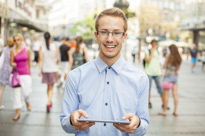 Portrait of young man using smart phone in city