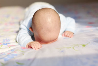 Cute baby lying on bed at home