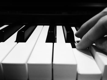 Cropped image of hand playing piano