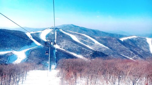 Close-up of ski lift against blue sky