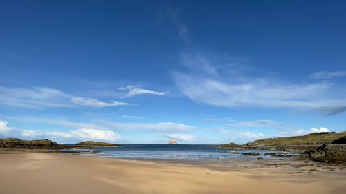 Scenic view of beach against blue sky