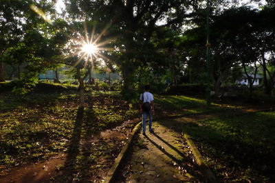 Rear view of man walking on bicycle