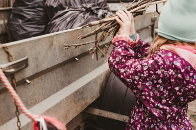 Child collects dry sticks in the trailer to take out with other garbage. 