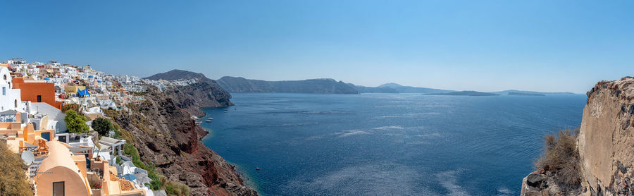 Panoramic view of sea and buildings against clear blue sky