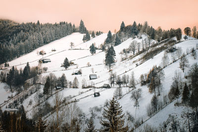 Scenic view of winter landscape in rural mountain area at sunset