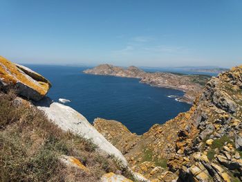 Scenic view of sea and mountains against blue sky