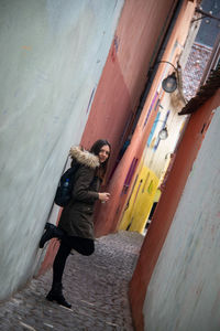 Full length of young man standing in alley